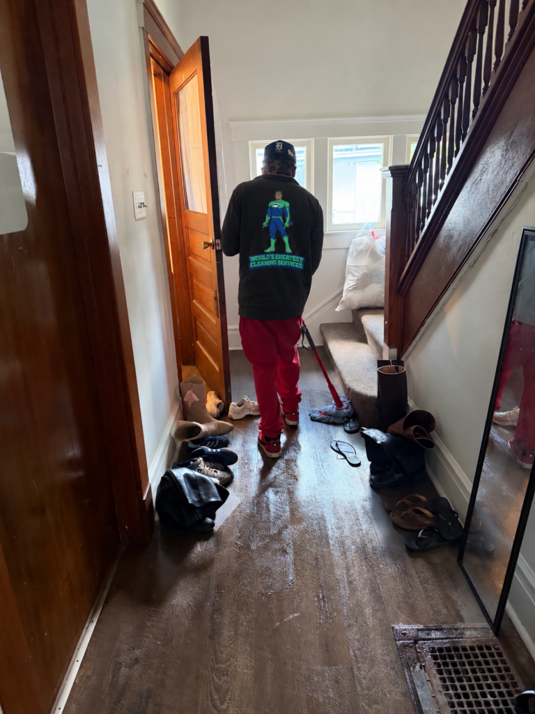 WGCS cleaner mopping a hallway in an Ann Arbor student home during a one-time deep clean